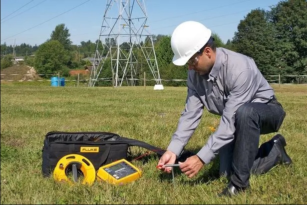 Técnico realizando medición de puesta a tierra en campo con equipo de medición